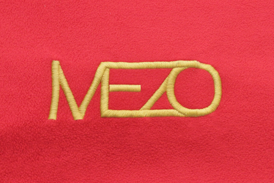 вышивка золотого цвета на красной ткани в приближении